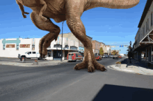 a t-rex is walking down the street in front of a building that says metro company