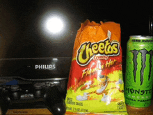 a bag of cheetos is next to a monster energy drink