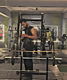 a man is taking a picture of himself in a gym while looking at his phone