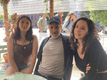 a man and two women pose for a picture while sitting at a table