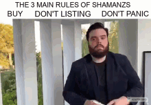 a man with a beard is standing in front of a window with a sign that says the 3 main rules of shamans