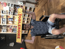 a man in a wheelchair is holding up a toblerone bar