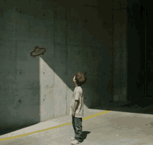 a young boy looks up at a drawing of an alien on the wall