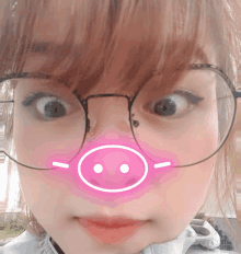 a girl wearing glasses has a pink pig nose drawn on her face