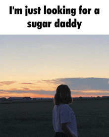 a girl standing in a field with the words i 'm just looking for a sugar daddy written above her