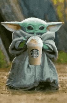 the baby yoda from star wars is drinking a starbucks drink .