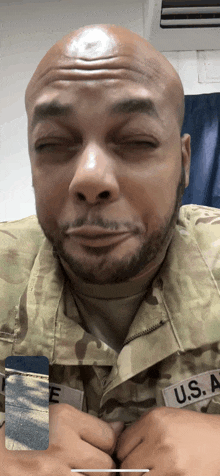 a man in a u.s. army uniform is making a face