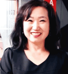 a woman is smiling in front of a sign that says a on it