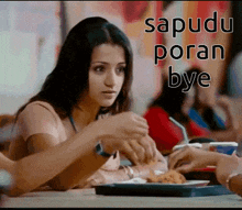 a woman is sitting at a table with a plate of food and the words " sapuduparan bye " above her