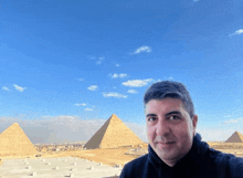 a man taking a selfie in front of the pyramids in egypt