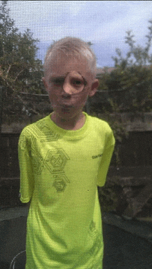 a young boy wearing a bright yellow shirt with a geometric design on it