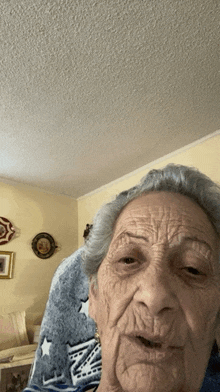 an elderly woman sitting in a chair with a blanket that says ny