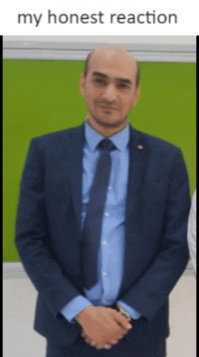 a man in a suit and tie stands in front of a green background with the words " my honest reaction "