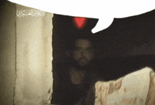 a speech bubble with arabic writing on it is above a man in a dark room