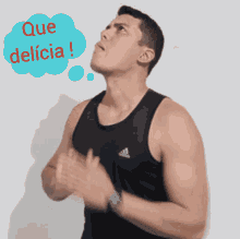 a man wearing a black adidas tank top looks up at a thought bubble that says que delicia