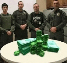 a group of police officers are standing around a table with stacks of green coins .