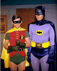 robin and batman are posing for a photo together