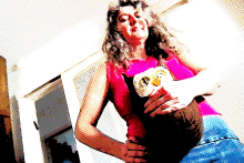 a woman in a pink top is holding a stuffed owl