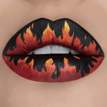 a close up of a woman 's lips with a fire design painted on them