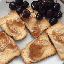 slices of toast with peanut butter and cherries on the side