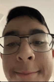 a close up of a person wearing glasses making a face