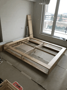 a wooden bed frame is being built in a room