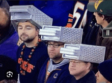 a group of men wearing graters on their heads in a stadium