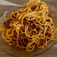 a plate of spaghetti with meat sauce and a fork on a table