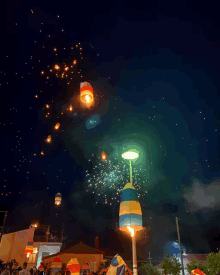 fireworks are displayed in the night sky with lanterns flying in the air