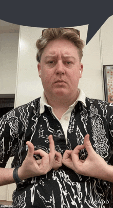 a man wearing a black and white shirt is making a peace sign with his hands