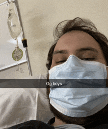 a man in a hospital bed wearing a face mask with the caption gg boys