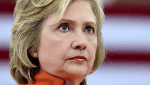 a close up of a woman 's face with a red and white flag in the background