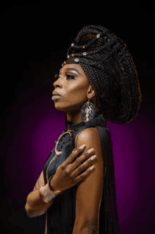 a woman wearing a braided headpiece and earrings looks to the side