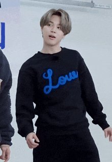 a person wearing a black sweatshirt with the word love written on it