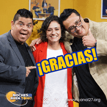 two men and a woman pose with a sign that says gracias on it