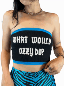 a woman wearing a black crop top that says " what would ozzy do "