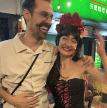 a man wearing a shirt that says jean michel basquiat smiles next to a woman in a corset