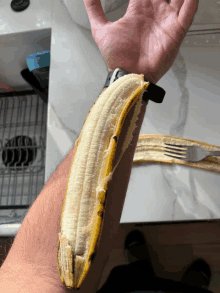 a person holding a banana on their wrist