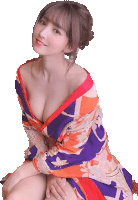 a woman in a colorful kimono is sitting on the floor .