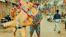 a man in a black and white shirt stands in front of a tiger statue