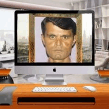 a computer monitor with a picture of a man in a frame on it .