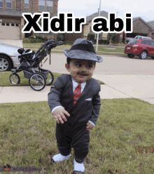 a baby dressed as a man in a suit and tie with the words xidir abi on the bottom