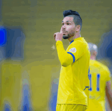 a soccer player wearing a yellow jersey with the number 1 on the back