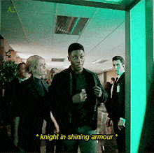 a group of people standing in a hallway with a caption that says " knight in shining armour "