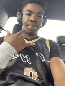 a young man wearing headphones and a jersey that says ' ucsd ' on it