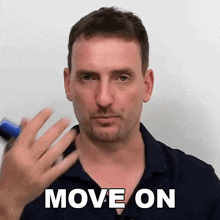 a man in a blue shirt is making a gesture that says move on