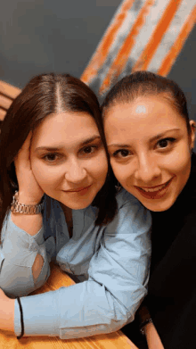 two women are posing for a picture and one has a watch on