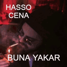 a man is smoking a cigarette with the words hasso cena buna yakar written above him