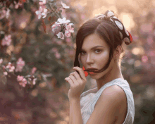 a woman with a scarf around her head holds a flower in her hand