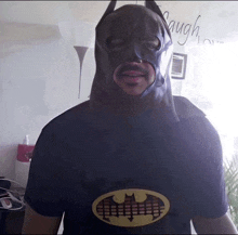 a man is wearing a batman mask and a batman t-shirt